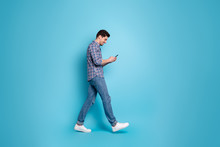 Full Length Body Size Photo Of Slender Positive Handsome Carefree Glad Optimistic Guy Holding Using Telephone In Hands Going Somewhere Isolated Pastel Background