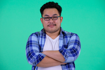 Young overweight Asian hipster man with arms crossed