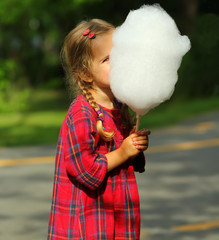 Wall Mural - Happy toddler girl eating cotton candy