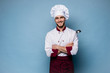 © opolja - Portrait of positive toothy chef cook in beret, white outfit having tools in crossed arms looking at camera.