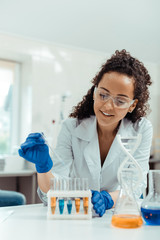 Wall Mural - delighted young woman looking at the test tubes