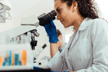 Wall Mural - joyful happy smart woman using the microscope