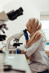 Wall Mural - serious thoughtful woman studying test samples in the bio lab