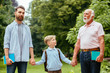 © Iryna - Family Generations concept: Father, son and Granddad, outdoors, in Nature, enjoying their Quality Time together, All in nice wear take child to school.
