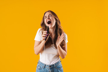 Poster - Image of excited caucasian woman wearing basic t-shirt singing while listening to music with cellphone and earphones