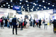 Blurred exhibition event in hall with many people on background. many businessmen are walking in the seminar