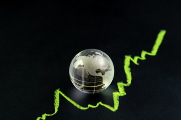 Wall Mural - USA or America stock and investment growth, decorate shiny glass globe with United State map on dark black blackboard with chalk drawing green line as stock return growth graph with copy space