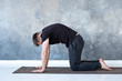 © RealPeopleStudio - Young yogi men practices yoga asana bitilasana or cat cow pose