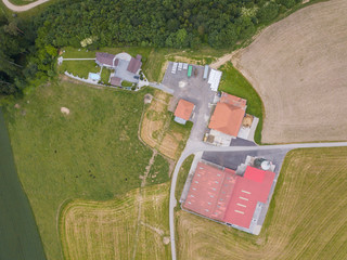 Sticker - Aerial view of rural farmhouse with red roof in green rural area in Switzerland.