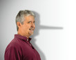© Michael O'Keene - Lying dishonest man with his growing long liar Pinocchio nose showing in his shadow