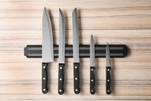 Magnetic Holder With Set Of Knives On Wooden Background