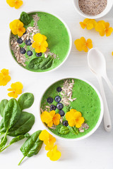 Wall Mural - green spinach smoothie bowl with blueberry, chia seed and edible pansy flowers