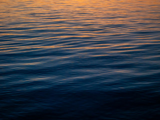 The texture of the water at sunset with sun reflections