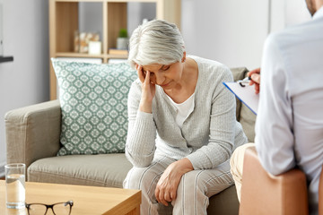 Wall Mural - geriatric psychology, mental therapy and old age concept - sad unhappy senior woman patient and psychologist with clipboard taking notes at psychotherapy session