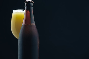 Poster - Close up Glass of beerand brown Bottle on a dark background behaid.
