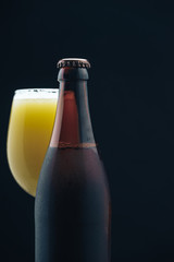 Poster - Close up Glass of beerand brown Bottle on a dark background behaid.