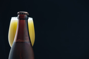 Poster - Close up Glass of beerand brown Bottle on a dark background behaid.