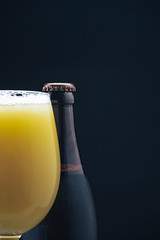 Poster - Close up Glass of beerand brown Bottle on a dark background behaid.