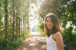 © tirachard - Happy young Asian woman traveler with backpack walking in forest. Hiker Asian woman with backpack walking on path in summer forest. Adventure backpacker travel people concept.