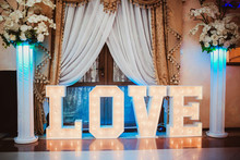 Wooden glowing love text letters. Rustic wedding dance floor lamp.