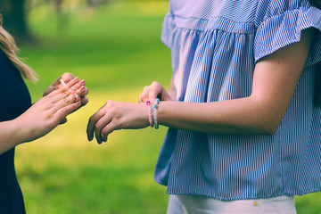 Wall Mural - Midsection of young woman putting crystal bracelet on her hand