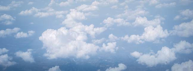 Wall Mural - wide panorama sky clouds above the clouds from airplane window for banner nature background