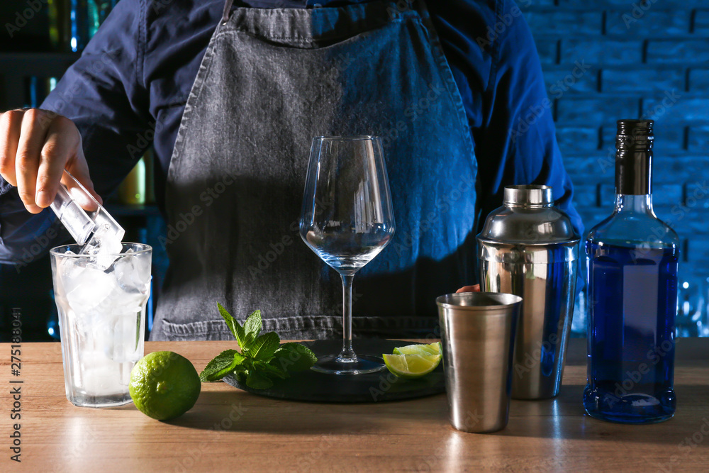 Barkeeper preparing Blue Lagoon cocktail at table in bar