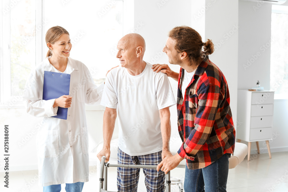 Young man visiting his elderly father in modern clinic