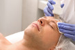 © Pixel-Shot - Handsome man undergoing procedure of facial peeling in beauty salon