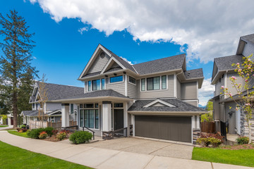 Wall Mural - Beautiful exterior of newly built luxury home. Yard with green grass and landscape.