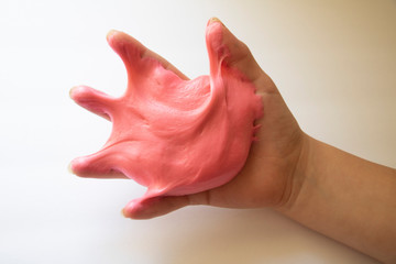 Wall Mural - Hands Manipulating Pink Slime Hands pulling, twisting, squeezing slime. Slime resembles bubble gum. Gooey, stretchy, flexible, satisfying, tactile experience. Gross texture. Childhood fun. Innocent pl