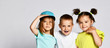 © FAB.1 - children on a light background: full body shot of three children in bright clothes, two girls and one boy. Triplets, brother and sisters.