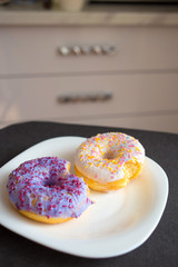 Two donuts with icing on a plate