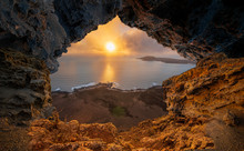 A View From A Natural Rock Cave To The Ocean During Sunset