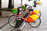 Fototapeta  - Electric bike rental station in urban setting.