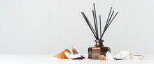 Aroma Reed Diffuser Bottle Home Fragrance With Rattan Sticks With The Scent Of Coconut And The Freshness Of The Tropics On White Background. Long Wide Banner With Copy Space.