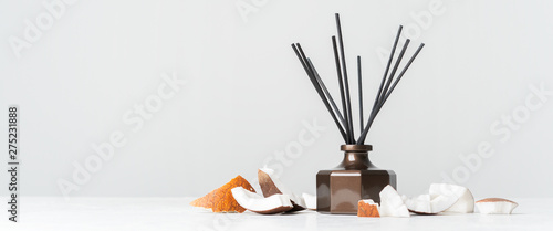 Fotografía Aroma reed diffuser bottle home fragrance with rattan sticks with the scent of coconut and the freshness of the tropics on white background