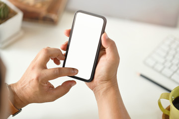 Cropped shot of businessman hand holding blank screen mobile phone at office