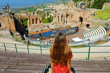 Aerial view of beautiful young woman looking ruins of the ancient Greek theater in Taormina, Sicily Italy