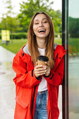 Sticker - Cheerful attractive young girl wearing raincoat