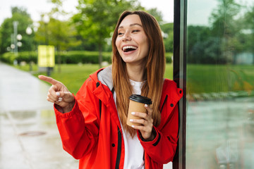 Poster - Cheerful attractive young girl wearing raincoat