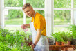 © Viacheslav Yakobchuk - Smiling man sprinkling plants in his flower shop.