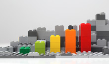 Progress Chart Made Of Brick Toys. Isometric Composition Of Colourful Toys On White Table.