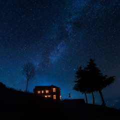 Silhouette of a girl jumping with a starry night background