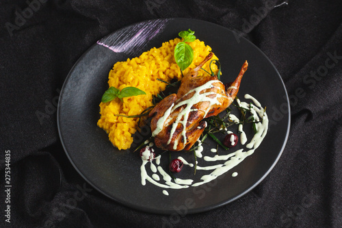 Fotografía Whole quail roasted with a golden crust, served with yellow milanese risotto and