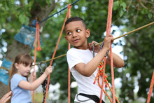 Little African-American Boy Climbing In Adventure Park. Summer Camp