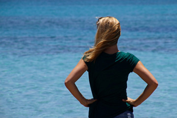 Blond woman looking at the sea in Elafonisi, Crete