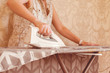 © Mihail - adult woman doing housewife work ironing textile
