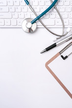 Stethoscope On Keyboard On White Table Background. Online Medical Information Treatment Technology Office Concept, Top View, Flat Lay, Copy Space