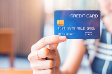 Wall Mural - Business woman hand holds a blue credit card.